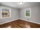 An empty bedroom with hardwood floors, neutral walls, and natural light from two windows at 2026 Swazey Dr, Decatur, GA 30032