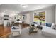 Bright open concept living area with hardwood floors, a modern sofa, and an eat-in kitchen at 2026 Swazey Dr, Decatur, GA 30032
