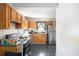 A compact kitchen design with wood cabinets, stainless steel refrigerator, and black and silver appliances at 207 Taylor Cir, Palmetto, GA 30268