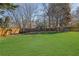 Large, grassy backyard featuring mature trees and a wooden play set at 340 Willow Crescent Way, Johns Creek, GA 30022