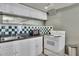 Basement kitchenette with white cabinets, black countertops, and green and white tiled backsplash at 340 Willow Crescent Way, Johns Creek, GA 30022