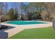 A large community pool is covered with a green tarp, surrounded by a concrete deck and grassy areas for recreation at 340 Willow Crescent Way, Johns Creek, GA 30022