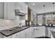 Modern kitchen featuring white cabinets, stainless steel appliances, and a black countertop at 340 Willow Crescent Way, Johns Creek, GA 30022