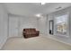 Living room with neutral carpet, a brown couch, a window, and a door at 340 Willow Crescent Way, Johns Creek, GA 30022