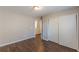 Neutral bedroom with wood-look flooring, closet, and open doorway, offering comfort and style at 4310 Alysheba Dr, Fairburn, GA 30213