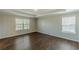 Bedroom featuring hardwood floors, neutral walls, crown molding and two large windows at 4310 Alysheba Dr, Fairburn, GA 30213