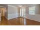 Spacious living room featuring hardwood floors, wainscoting, and large french doors at 4310 Alysheba Dr, Fairburn, GA 30213