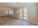 View of the carpeted living room area featuring a glass door that leads to the outdoor space and many windows at 4310 Alysheba Dr, Fairburn, GA 30213