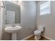 Cozy powder room with pedestal sink, toilet, wood-look flooring, and a window providing natural light at 4310 Alysheba Dr, Fairburn, GA 30213