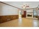 Living room offering a fireplace, wood wainscoting, a window and ceiling fan at 6565 Katie Ln, Morrow, GA 30260