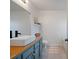 Bathroom with a modern sink, wood countertop, gray tile flooring, and blue cabinetry at 923 Wexford Way, Auburn, GA 30011
