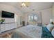 Bright main bedroom with large bed, TV, and window view; ideal for rest and relaxation at 923 Wexford Way, Auburn, GA 30011