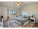 A cozy main bedroom with a ceiling fan, large windows, and a decorative rug for a relaxed ambiance at 923 Wexford Way, Auburn, GA 30011
