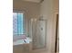 Bathroom featuring a glass enclosed shower and decorative window above a tub at 1630 Stonehaven, Cumming, GA 30040