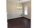 Formal dining room with dark wood floors and traditional chandelier at 1630 Stonehaven, Cumming, GA 30040