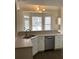 Kitchen sink, countertops, and stainless steel dishwasher with a view to a bright breakfast nook at 1630 Stonehaven, Cumming, GA 30040