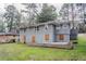 View of home with a gray painted brick, windows, grass lawn, and landscaping at 1826 Meadowglades Dr, Decatur, GA 30035