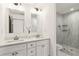 Bright bathroom with double sink vanity, quartz counters, and a glass-enclosed tiled shower at 2206 Loring Ct, Decatur, GA 30032