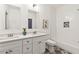 Bright bathroom featuring double sink vanity with quartz counters, white cabinets and decorative grey patterned floors at 2206 Loring Ct, Decatur, GA 30032