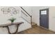 Welcoming entryway featuring hardwood floors, a modern console table, and a stylish blue door leading to the staircase at 2206 Loring Ct, Decatur, GA 30032