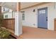 Inviting front porch featuring a stylish blue door, wooden decking, white brick, and decorative wooden railing at 2206 Loring Ct, Decatur, GA 30032