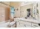 Well-lit full bathroom featuring combination tub/shower and a white vanity at 1030 Chateau Forest Rd, Hoschton, GA 30548