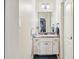 Bathroom featuring a single vanity, and a mirror in a room with white walls and dark floors at 1030 Chateau Forest Rd, Hoschton, GA 30548