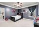 Cozy bedroom featuring a ceiling fan, large windows, and a dark-colored bed with built-in shelving at 1030 Chateau Forest Rd, Hoschton, GA 30548