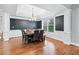 Dining room showcasing hardwood floors, custom trim, and a modern chandelier at 1030 Chateau Forest Rd, Hoschton, GA 30548