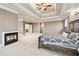 Large primary bedroom featuring trey ceilings, fireplace, and king size bed at 1030 Chateau Forest Rd, Hoschton, GA 30548