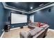 Home theater room with a large screen, comfortable seating, and dim lighting for immersive experience at 1030 Chateau Forest Rd, Hoschton, GA 30548