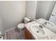 Convenient half bathroom featuring a vanity with sink, mirror, and toilet, perfect for guests at 122 Sanders Walk, Mcdonough, GA 30252