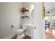 Stylish powder room with pedestal sink, decorative shelves, and hardwood floors at 685 Trailwood Sw Ln, Marietta, GA 30064