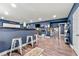 Finished basement featuring a stylish bar with seating, TV, and display shelving and dark blue walls at 1353 Wilson Manor Cir, Lawrenceville, GA 30045