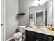 Powder room features a stylish vanity and toilet, with stairs reflected in the mirror at 1353 Wilson Manor Cir, Lawrenceville, GA 30045