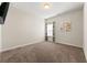 Empty bedroom with neutral walls, carpet floors, and a window with colorful curtains at 1353 Wilson Manor Cir, Lawrenceville, GA 30045