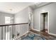 Hallway with decorative railing and chandelier leads to a bathroom and other rooms at 1353 Wilson Manor Cir, Lawrenceville, GA 30045