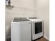 Efficient laundry room featuring a modern washer and dryer set with shelving for storage at 1353 Wilson Manor Cir, Lawrenceville, GA 30045