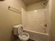 Standard bathroom featuring a toilet, shower-tub combo with white tile, and a chrome towel rack at 5488 Wexford Pass, Atlanta, GA 30349