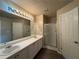 Bathroom with double sink vanity, shower, and decorative Hollywood-style lighting at 5488 Wexford Pass, Atlanta, GA 30349