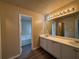 Bathroom vanity with double sinks, white cabinets, and a large mirror with Hollywood-style lighting at 5488 Wexford Pass, Atlanta, GA 30349