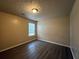 Neutral bedroom with dark wood-look floors and patterned ceiling, featuring a double-hung window at 5488 Wexford Pass, Atlanta, GA 30349