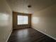 Neutral bedroom with dark wood-look floors and patterned ceiling, featuring a double-hung window at 5488 Wexford Pass, Atlanta, GA 30349