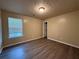 Neutral bedroom with dark wood-look floors and patterned ceiling, featuring a double-hung window at 5488 Wexford Pass, Atlanta, GA 30349