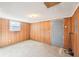 A partially finished basement features concrete floors, a door to the exterior, and wood paneling at 80 Brownsville Ext., Powder Springs, GA 30127