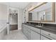 Modern bathroom featuring double vanity, granite counters, and stylish marble floors at 1360 Flora Dr, Conyers, GA 30094