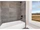 Bathroom with a white tub and grey tile surround at 1360 Flora Dr, Conyers, GA 30094