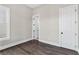Neutral-toned bedroom featuring wood floors, white trim, a window for natural light, and two interior doors at 1360 Flora Dr, Conyers, GA 30094
