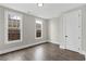 Well-lit bedroom features hardwood floors, neutral paint, and a double hung windows at 1360 Flora Dr, Conyers, GA 30094