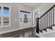 Bright foyer with a white-framed front door, wood floors, staircase with black metal railings, and a large window at 1360 Flora Dr, Conyers, GA 30094